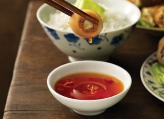 Just drop a cold grain of rice in it, real or fake fish sauce will become clear instantly