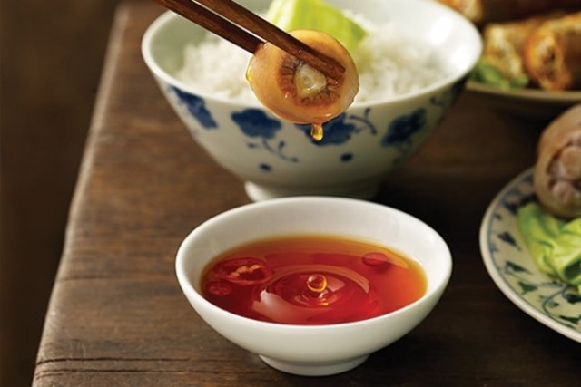 Just drop a cold grain of rice in it, real or fake fish sauce will become clear instantly
