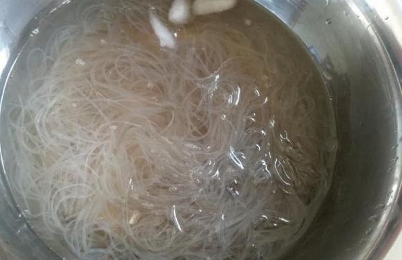 Does soaking rice noodles in hot or cold water make the fried spring rolls crispy and how long should it be soaked?