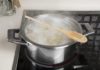 What is the purpose of placing a wooden spoon over a boiling pot?