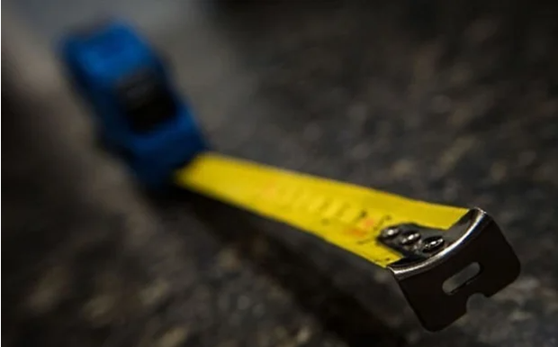 What is the Purpose of the Hole and the Serrated Edge on the End of a Measuring Tape?